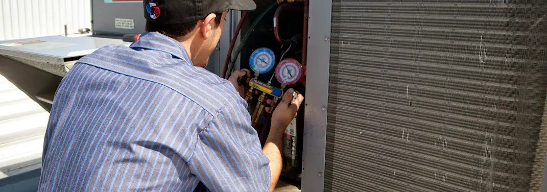HVAC technician servicing a condenser unit in East Los Angeles