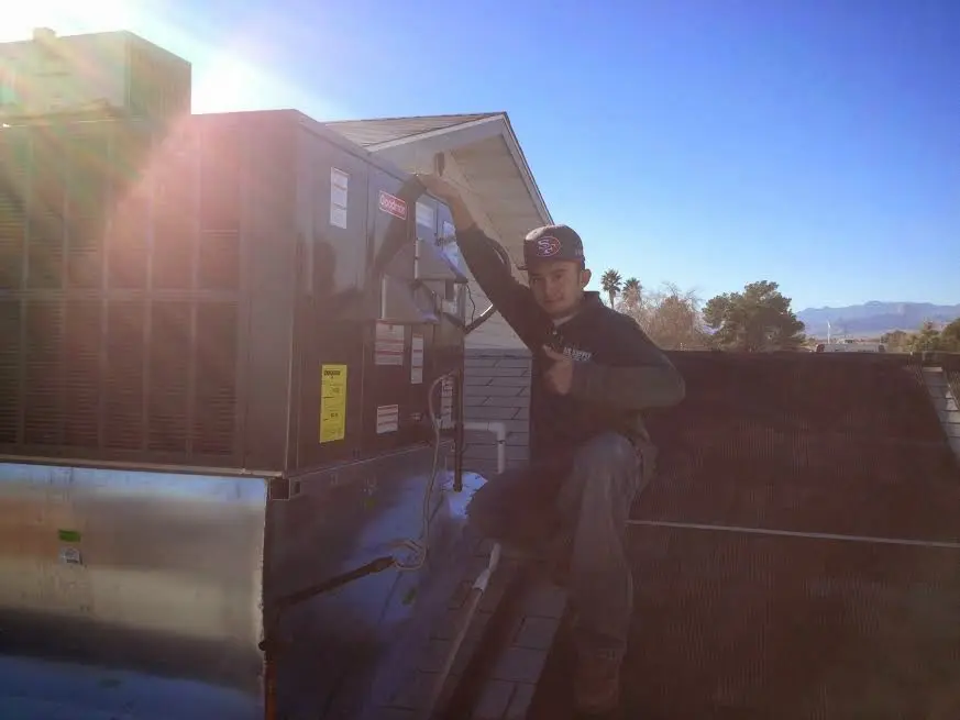 HVAC technician performing Air Duct Repair on a rooftop unit in East Los Angeles